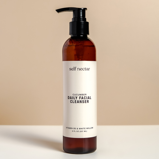  A refreshing cucumber daily facial cleanser in a sleek amber bottle with a pump dispenser on a neutral-colored surface. The product is labeled as a daily facial cleanser, featuring a clean and minimalist design for a revitalizing skincare routine. 