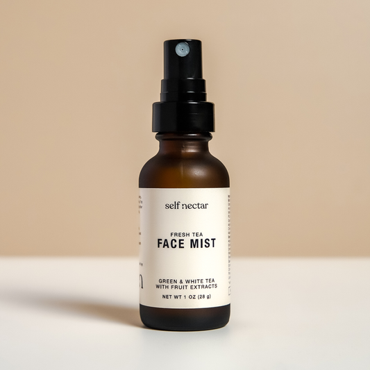 A rejuvenating fresh tea face mist in an amber spray bottle, presented in a stylish container on a neutral-colored surface. The product is labeled as a face mist, featuring a clean and minimalist design for a refreshing and hydrating skincare experience.