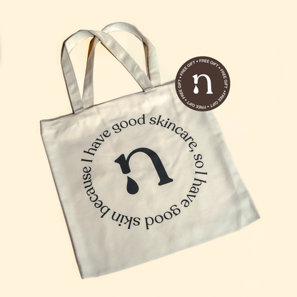 : A chic tote bag, an elegant free gift included in the skincare package. The tote bag is featured prominently, adorned with a 'Free Gift' sticker, adding a delightful touch to the skincare collection. The neutral background complements the sophisticated 